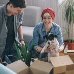 Young couple with their dog moving into their new house